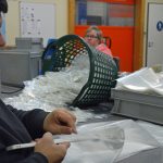 Das Bild zeigt einen Mitarbeiter bei Verpackungstätigkeiten.