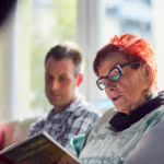 Das Bild zeigt eine Mutter, die aus einem Buch vorliest.