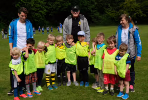 Das Bild zeigt die Fußballmannschaft der Kita Schatzkiste mit Betreuer*innen und dem Trainer.