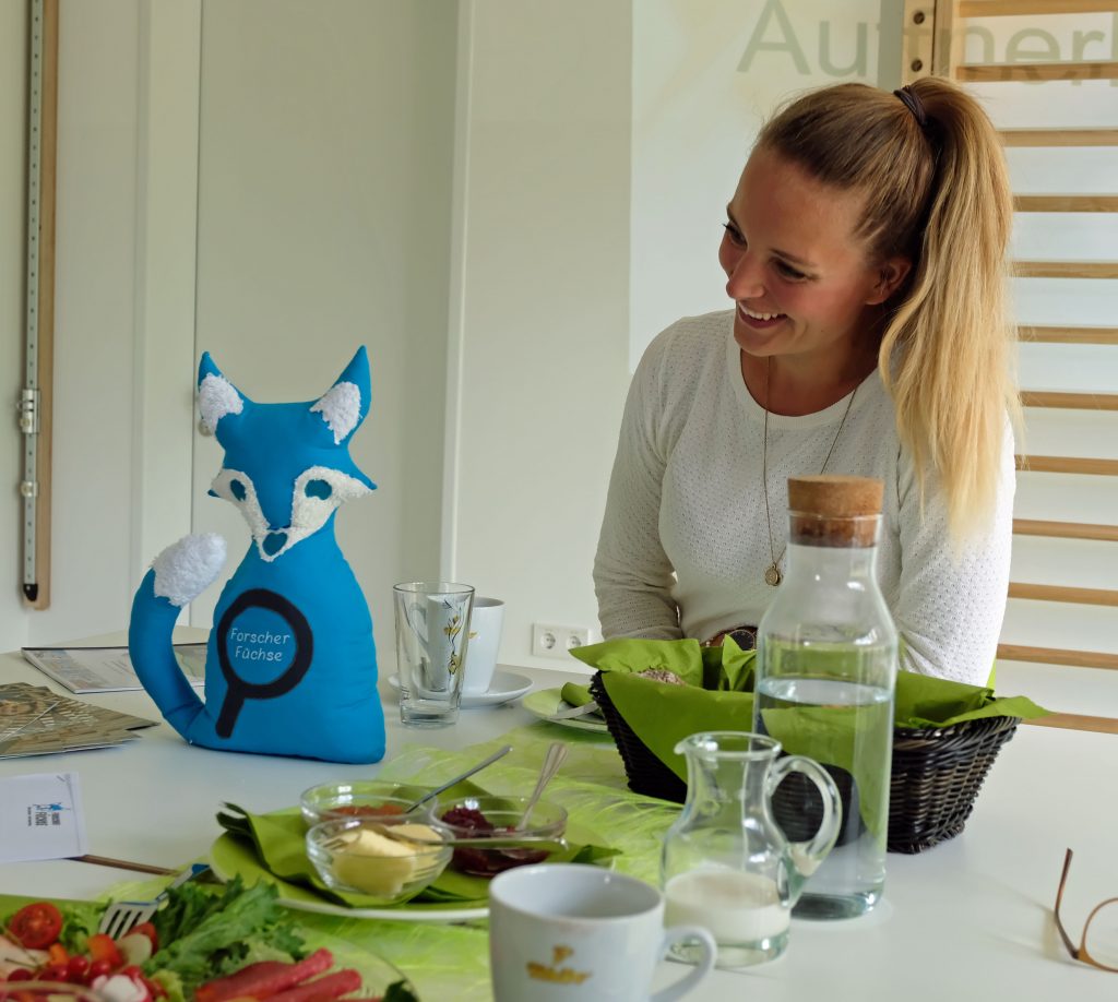 Das Bild zeigt Kita-Leiterin Sina Caspers mit einem "Forscher-Fuchs" aus Filz.