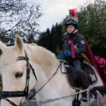 Das Bild zeigt Benett als Sankt Martin auf einem Pferd.