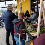 Das Bild zeigt Besucher an einem Verkaufsstand.