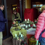 Das Bild zeigt Besucher an einem Verkaufsstand.