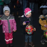 Das Bild zeigt drei Kinder mit ihren Laternen.